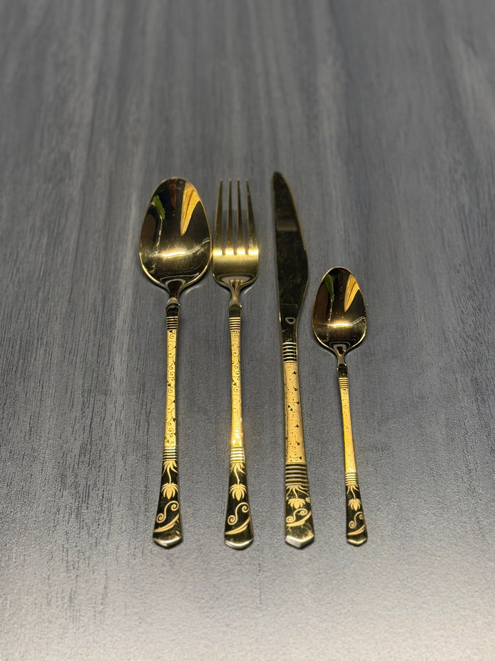 Luxury gold stainless steel cutlery set including spoon, fork, knife, and teaspoon with decorative engraved handles for catering and hospitality use.